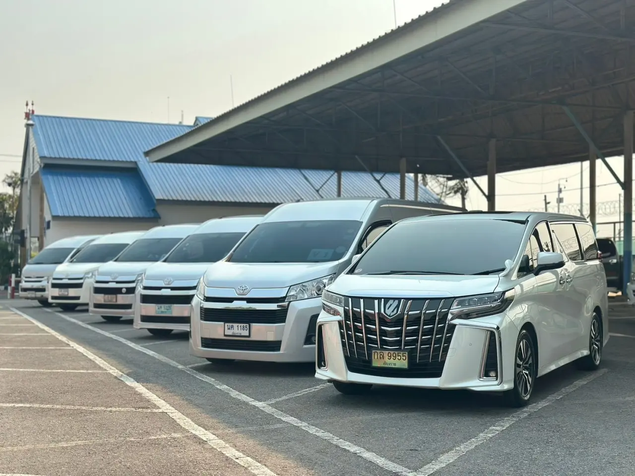 รถตู้ Toyota Commuter ของรถเช่าเชียงรายจอดเรียงใต้อาคารจอดรถ