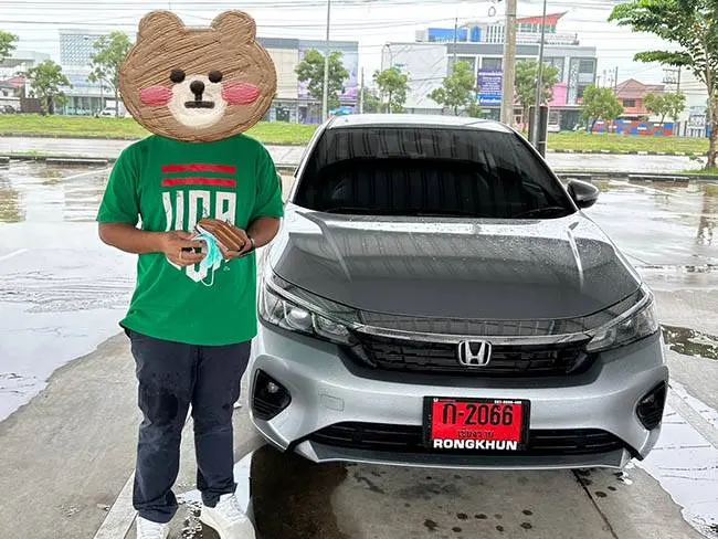 ลูกค้ายืนข้างรถเก๋ง Honda City สีเงินป้ายแดง